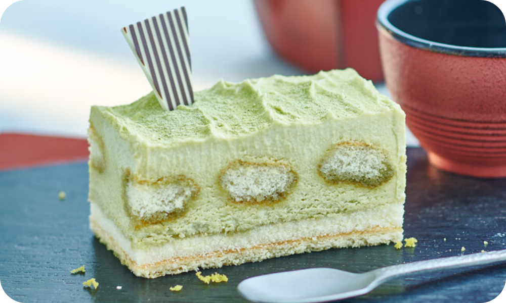 zart-grüne Matcha-Schnitte auf schwarzem Teller